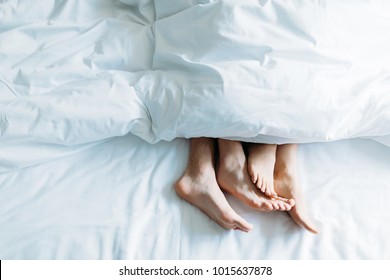 cropped image of boyfriend and girlfriend lying in bed under blanket - Powered by Shutterstock
