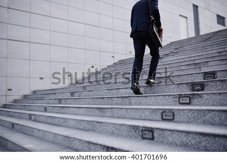 Cropped image of business person going up the stairs