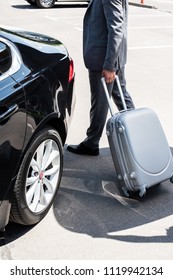  Cropped Image Of Businessman Carrying Wheeled Bag Near Car At Street 