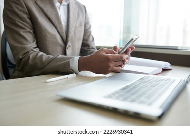 Cropped image of businessman checking text messages in smartphone - Shutterstock ID 2226930341
