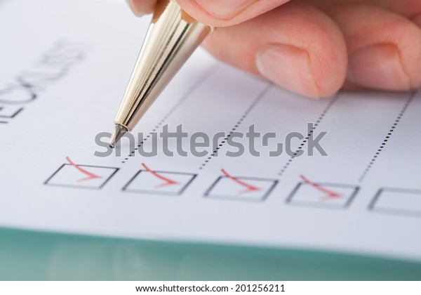 Cropped image of businessman preparing checklist at\
office desk