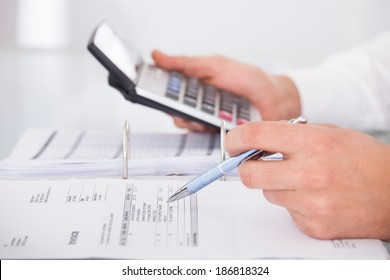 Cropped Image Of Businessman Using Calculator In Office