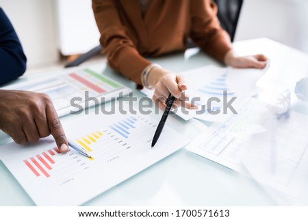 Cropped Image Of Businesswoman Writing On Graph At Desk In Office 