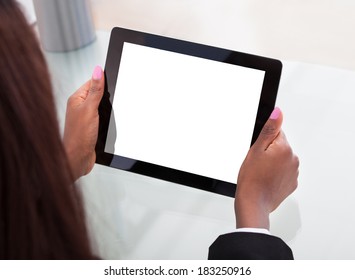 Cropped Image Of Businesswoman's Hands Holding Digital Tablet At Desk In Office