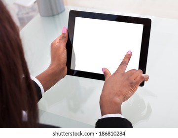 Cropped Image Of Businesswoman's Hands Holding Digital Tablet At Desk In Office