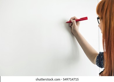 Cropped image of businesswomen writing on whiteboard in creative office - Powered by Shutterstock