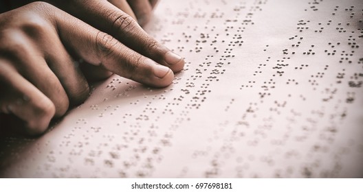 Cropped image of child using braille to read book at school - Powered by Shutterstock