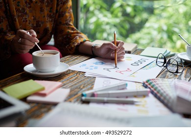 Cropped image of designer drinking coffee when working on logo - Shutterstock ID 493529272