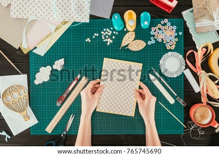 cropped image of designer holding template for scrapbooking postcard