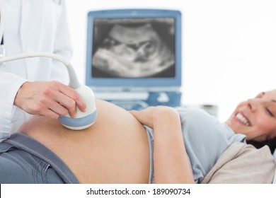 Cropped image of doctor performing ultrasound on pregnant woman in clinic - Powered by Shutterstock