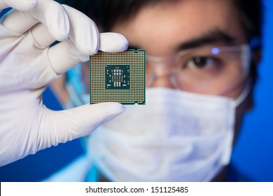 Обрезанное изображение инженера, показывающего компьютерный микрочип на переднем плане