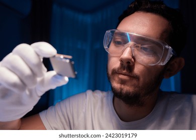 Cropped image of an engineer showing a computer microchip on the foreground
