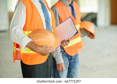 Cropped image of engineers with orange hard has ready to work - Shutterstock ID 667771297