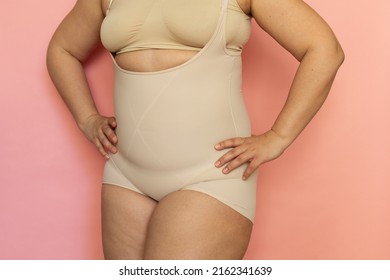 Cropped image of fat overweight woman in special fitness beige shape wear. Fast gain weight with pregnancy. Body health care. Visceral obesity, dehydrated dozed body. Skin puffiness. Close up