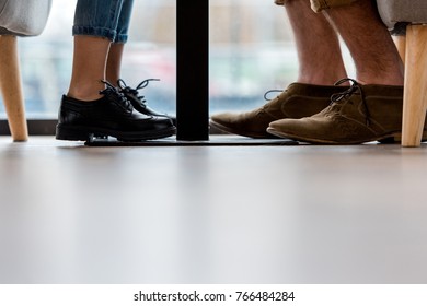 Cropped Image Of Father And Daughter Legs Under Table