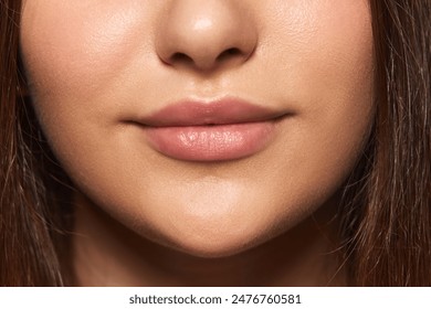 Cropped image of female face, chin, lips and nose. Perfect, smooth, well-kept skin, natural lips. Face lifting. Concept of natural beauty, skincare, cosmetology and cosmetic products ads