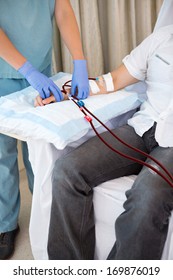 Cropped image of female nurse adjusting patient's dialysis tubing
