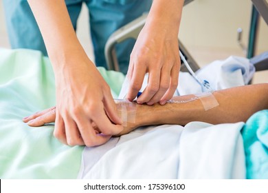 Cropped Image Of Female Nurse Starting An IV Line