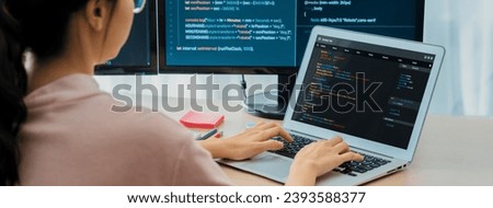 Cropped image of female web developer coding on laptop while computer displayed program and software code at modern office. Close up businesswoman hand focus on analysis data. Burgeoning.