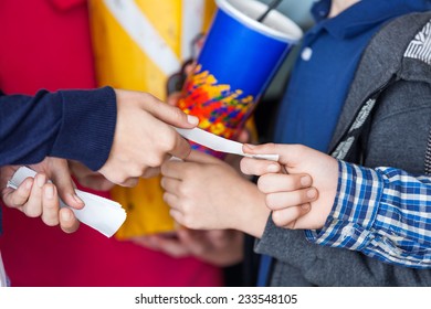 Cropped Image Of Female Worker Taking Movie Tickets From Siblings At Cinema