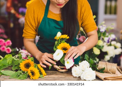 Cropped image of florist arranging flowers in the shop - Powered by Shutterstock