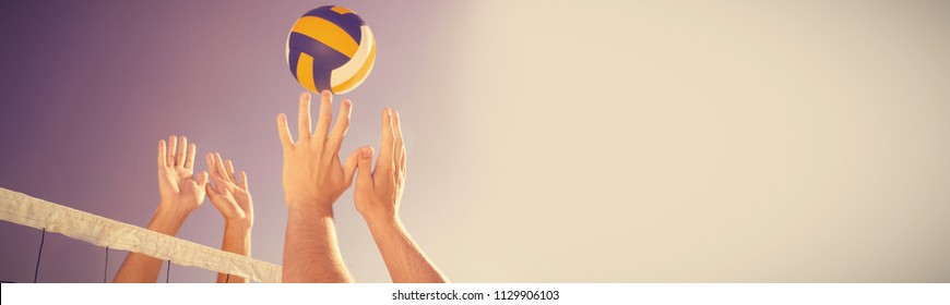 Cropped image of friends playing volleyball at beach - Powered by Shutterstock