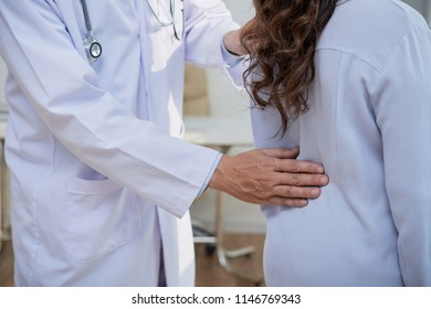 Cropped image of general practitioner checking spine of female patient during annual check-up - Shutterstock ID 1146769343
