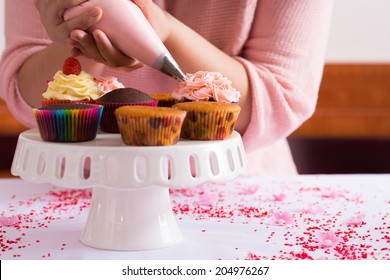 Cropped Image Of Girl Decorating Cupcakes