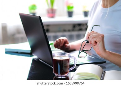 Cropped Image Of A Girl Or Woman Working On Quarantine From Home On The Kitchen Wearing Pijama.Home Office Or Distance Learning Concept. Freelance Or E-learning.