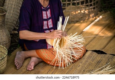 Cropped image of grandmother living in the countryside weaving bamboo making basket crafts at house. Handicrafts of local elderly people, Thailand - Powered by Shutterstock