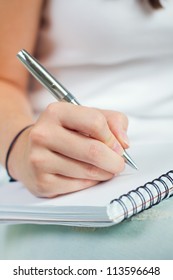 Cropped Image Of Hand Of Young Woman Taking Notes