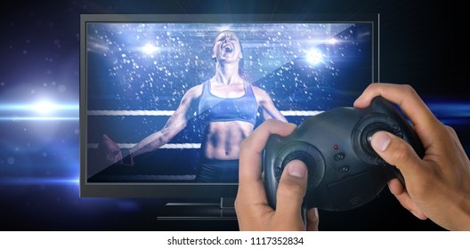 Cropped image of hands holding controller against black background with spark