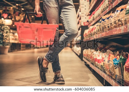 Cropped image of handsome man with a market basket doing shopping at the supermarket