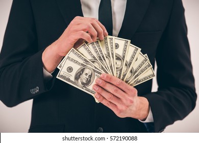 Cropped Image Of Handsome Young Man In Suit Holding Money, On Gray Background