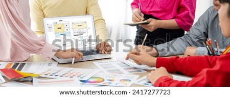 Cropped image of interior designer team discuss the material color while laptop displayed website wireframe designs for mobiles app and website. Creative design and business concept. Variegated.