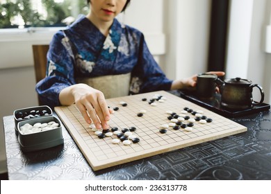 Cropped Image Of Japanese Girl Playing Wei Qi Game