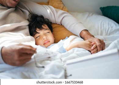 Cropped Image Of Little Boy Sleeping At Daytime In His Grandpa's Arm.