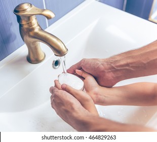 Cropped image of little girl and her father washing hands using soap in bathroom at home - Powered by Shutterstock