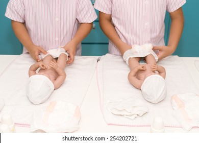 Cropped Image Of Little Nurses Changing Diapers Of Baby Dolls