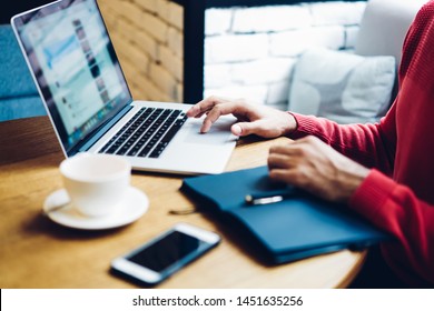 Cropped image of male freelancer working with online website system checking settings and editing program code via modern laptop computer, skilled man developing netbook application connected to wifi