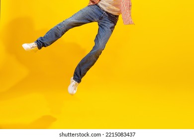 Cropped Image Of Male Legs In Jeans And White Sneakers Isolated Over Yellow Studio Background. Uncertainty. Concept Of Emotions, Facial Expression, Lifestyle, Fashion, Youth