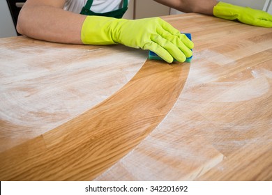 Cropped image of man cleaning dust on wooden table at home - Powered by Shutterstock