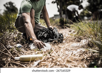 Cropped Image Of Man Collecting Litter In Forest