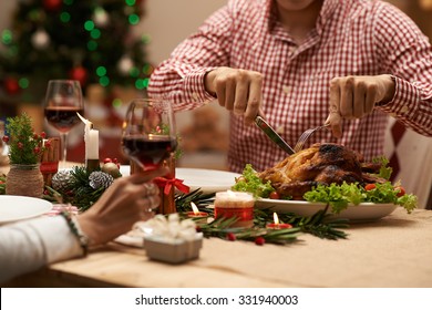 Cropped Image Of Man Cutting Roasted Chicken At The Christmas Family Dinner