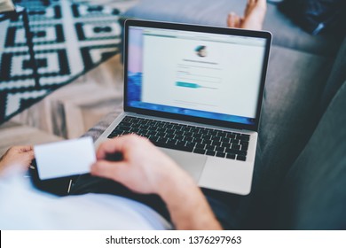 Cropped image of man holding credit card while making online money transaction via laptop computer connected to wireless internet at home, male user making shopping in web stores on netbook  - Shutterstock ID 1376297963