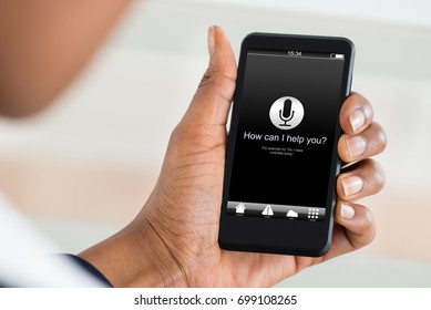 Cropped Image Of Man Holding Mobile Phone With How Can I Help You? Text