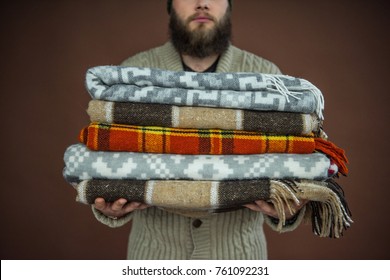 Cropped Image Of Man Holding Pile Of Blankets