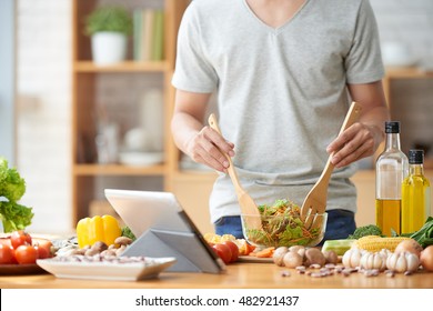 Cropped image of man mixing salad he made - Shutterstock ID 482921437
