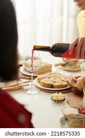 Cropped Image Of Man Pouring Wine In Glasses Of Party Guests