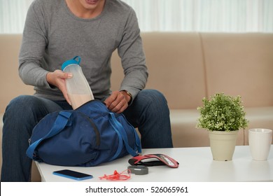 Cropped Image Of Man Putting Things For Sport Training In The Bag